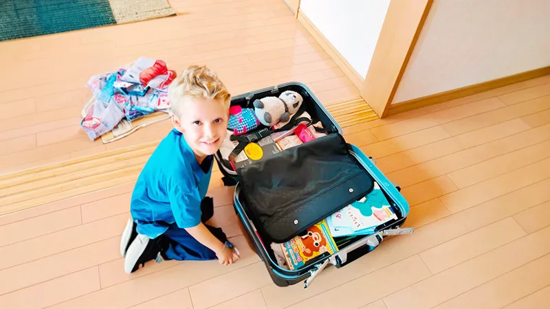子供がスーツケースに荷造りしている