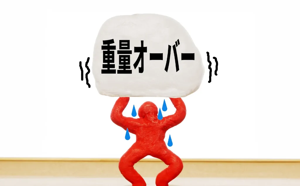 重量オーバーの荷物を下から支える人