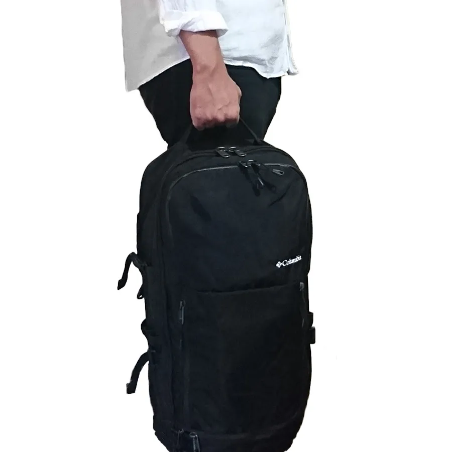 男性がColumbia Pepper Rock 36L の持ち手をもって立っている