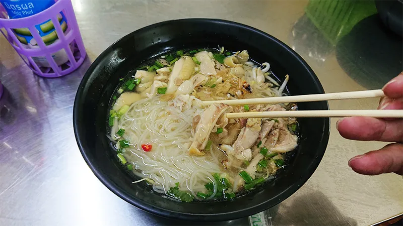 Soiブッカオ名無し食堂の鶏肉中細米麺を箸でつまむ