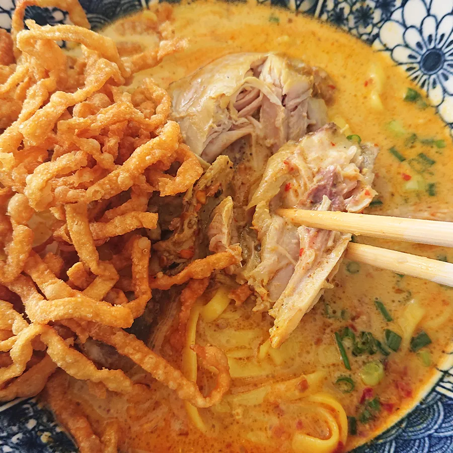 カオソーイの鶏肉をほぐして食べる